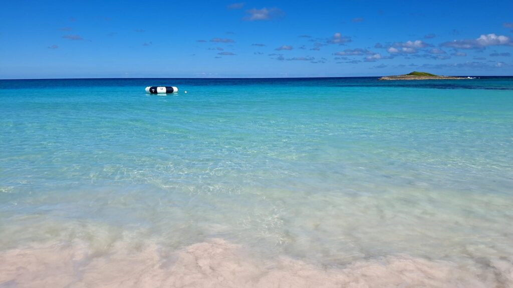 Mare turchese dei Caraibi con un isolotto all'orizzonte